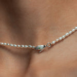 Model wearing Paola Vilas necklace in sterling silver with emerald and pearls