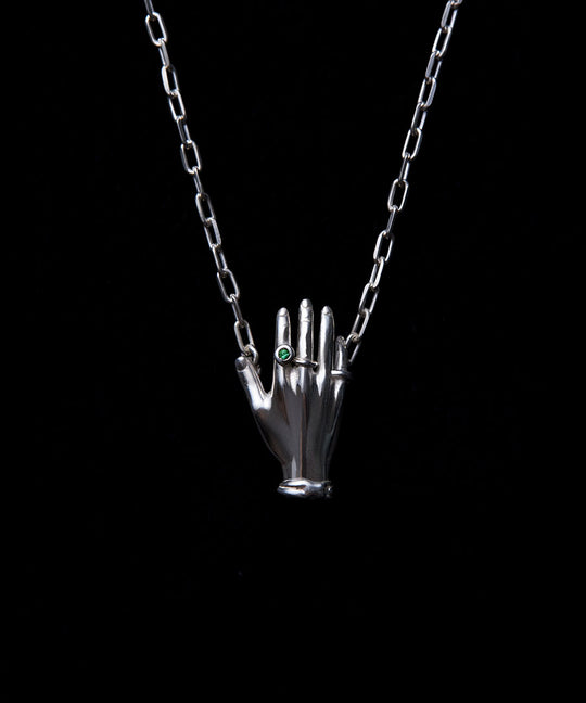 Necklace in sterling silver featuring a hand adorned with emerald