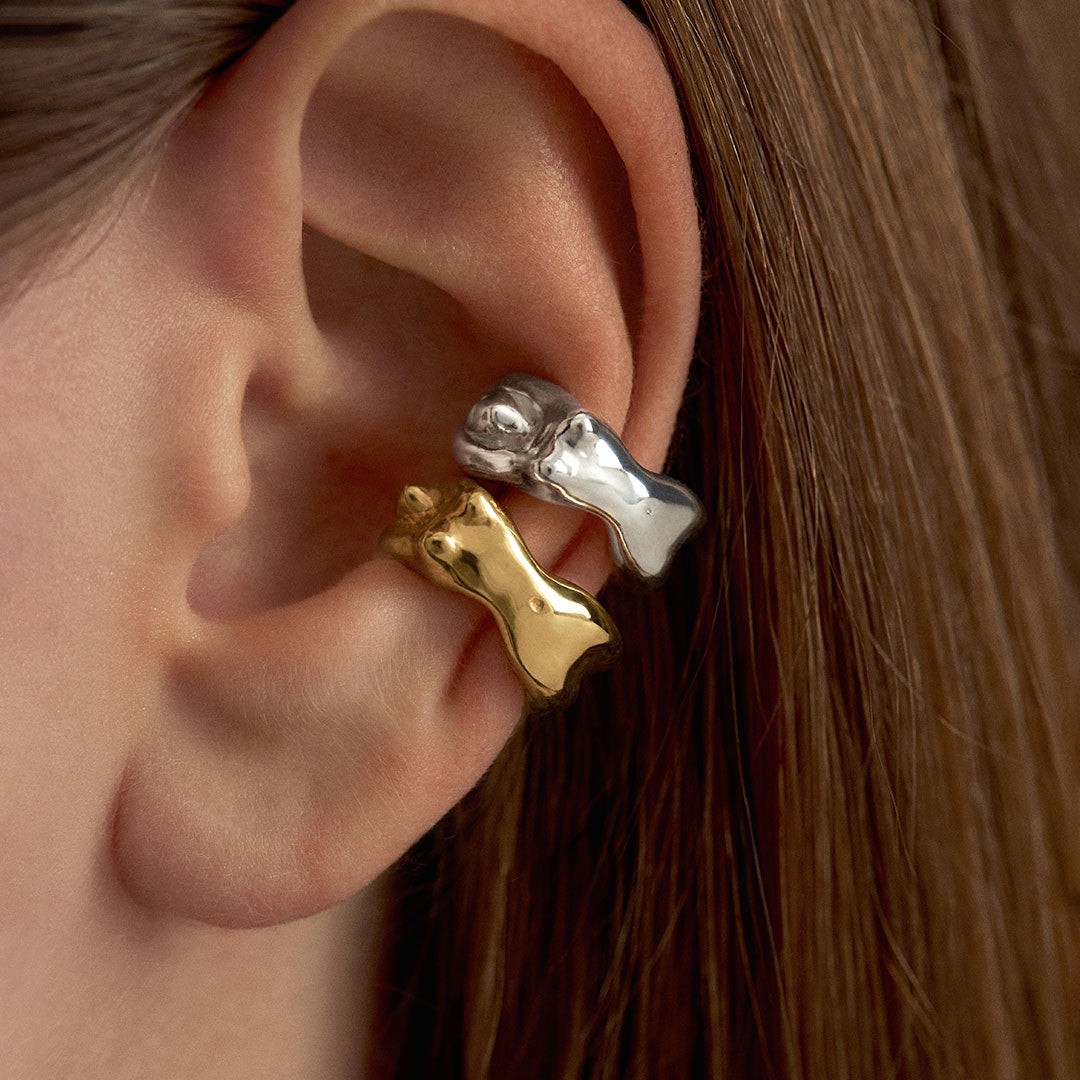Model wearing sterling silver earcuffs with 18k gold plating featuring female bodies